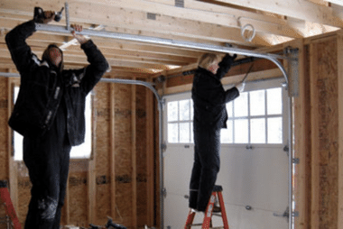 Workers building and fitting a new garage door