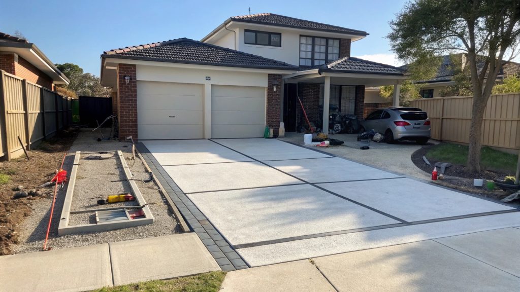 Property prepared for garage door installation with clear driveway access and organized materials