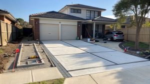 Property prepared for garage door installation with clear driveway access and organized materials