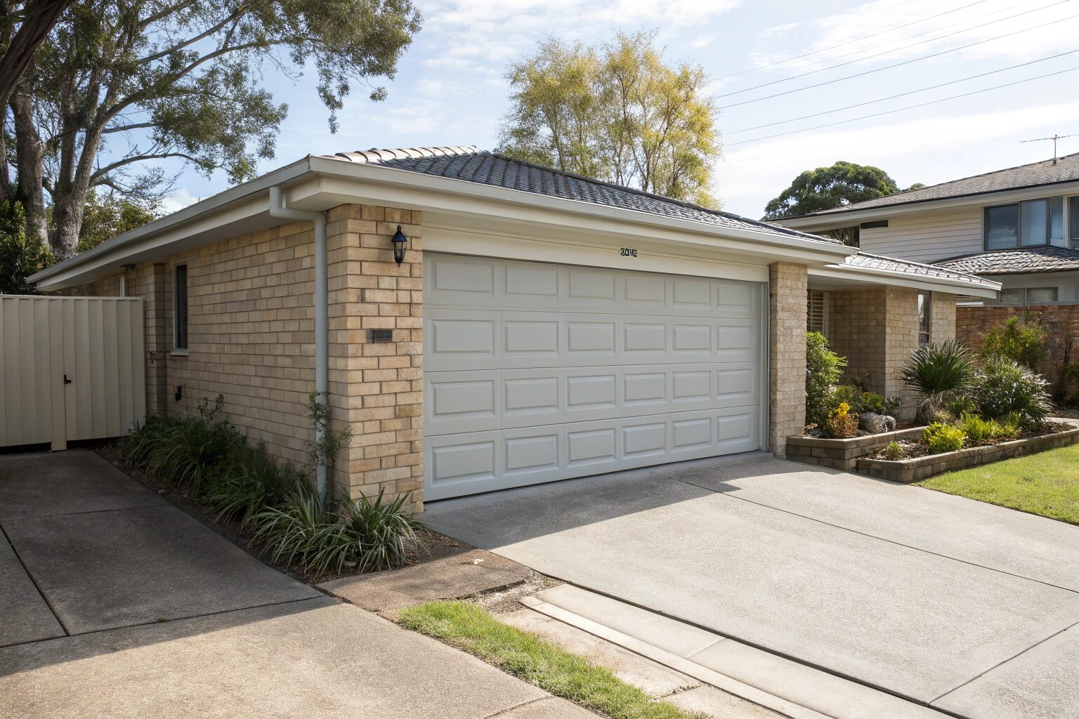 Freshly installed light grey panel lift garage door on a Sydney home